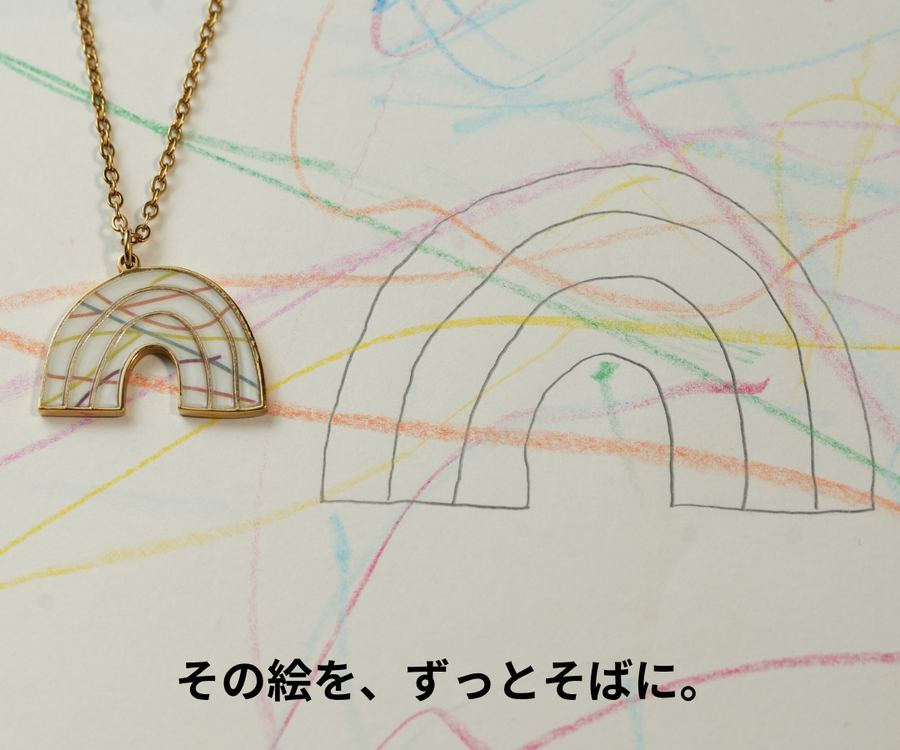 子どもが描いた虹の絵と、その絵からつくった虹のペンダント